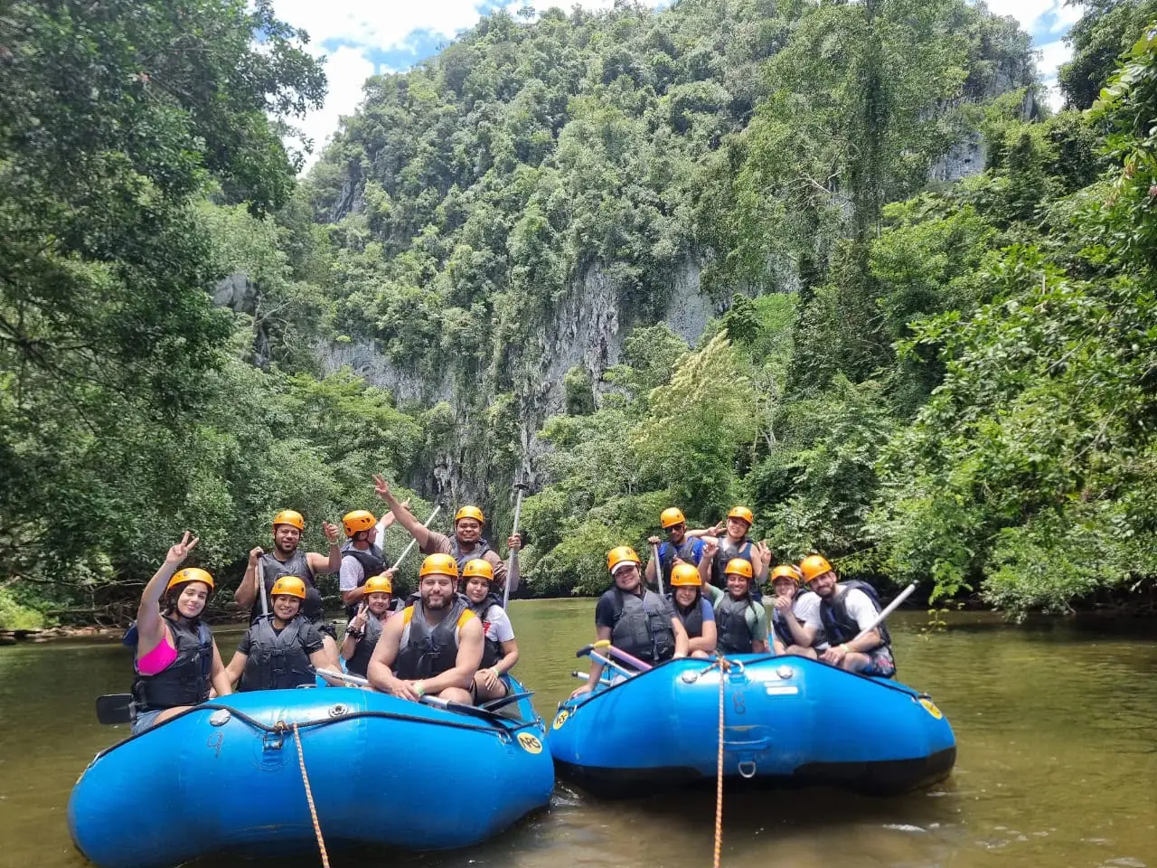 Grupo en balsas de rafting en un río entre paredes de roca